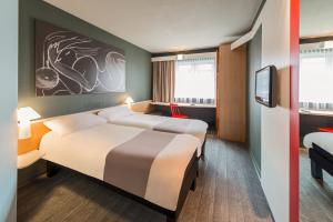柏林宜必思柏林斯潘道酒店的一间酒店客房,设有两张床和电视