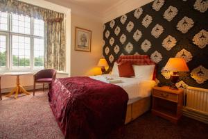 北安普敦聚焦威斯顿庄园酒店的配有一张床、一张书桌和一扇窗户的酒店客房