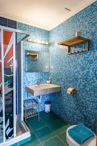 巴勒尔卡普登木屋旅馆的蓝色瓷砖浴室设有水槽和淋浴