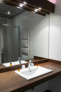 拉兰Hôtel d'Ossau的一间带水槽和镜子的浴室