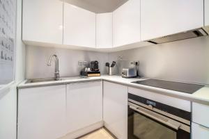 里尔LA CABANE Lille Centre的厨房配有白色橱柜和水槽