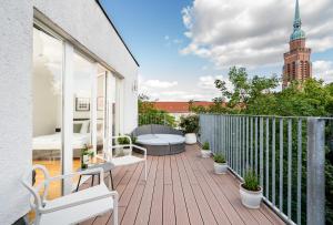 柏林BENSIMON apartments Prenzlauer Berg的阳台设有木制甲板和沙发