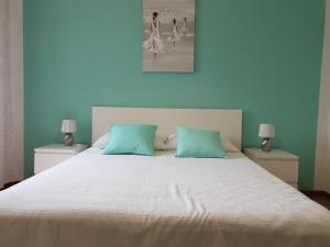 茨雷斯Guesthouse Fatuta的一间卧室配有一张大床和两个绿色枕头