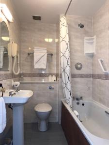 都柏林哈维斯酒店的一间带水槽、浴缸和卫生间的浴室