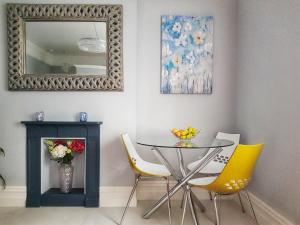 利默里克Elegantly Restored Suite in Historic Limerick的一间带桌椅和镜子的用餐室