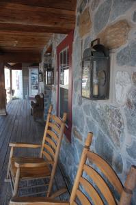 兰开斯特兰卡斯特乡村旅馆的门廊上设有两把木椅和石墙
