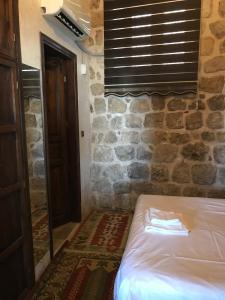 马尔丁卡斯瑞阿巴斯酒店的一间卧室设有一张床和石墙