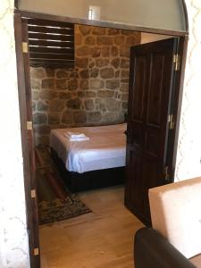 马尔丁卡斯瑞阿巴斯酒店的一间小卧室,卧室内有一张砖墙床