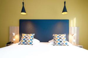 索恩河畔自由城普莱桑斯西佳酒店的卧室内的两张床,配有两个枕头