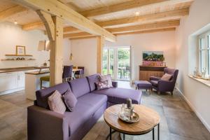翁德洛Heidjers Hus Undeloh的客厅配有紫色沙发和桌子