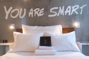 特罗姆瑟特罗姆瑟精致酒店的显示你坐在床上很聪明的标志