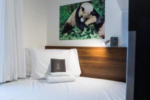 特罗姆瑟特罗姆瑟精致酒店的一间酒店客房,床上挂着熊猫照片