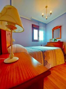 巴雷罗斯Casa Eloy的一间卧室配有一张床和一张带台灯的桌子