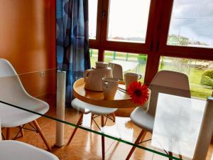 巴雷罗斯Casa Eloy的一张带椅子的玻璃桌,上面有花瓶