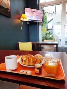 布雷斯特Hotel de la Gare Brest的盘子,盘子上放有面包和橙汁