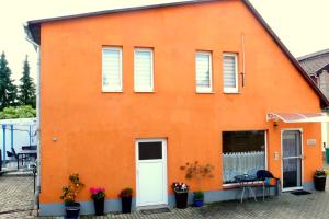 哈尔伯施塔特Ferienhaus "Harzblick"的一座橙色的建筑,设有白色的门和窗户