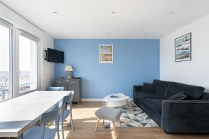 滨海布洛涅"Les Mouettes"的带沙发和蓝色墙壁的客厅
