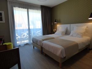 圣弗卢尔Cit'Hotel Grand Hotel L'Etape的酒店客房设有两张床和大窗户。