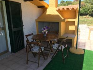 罗格桑托Casa di Campagna in Gallura的带壁炉的庭院配有桌椅