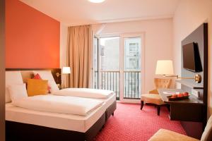 柏林Gold Palais Hotel的酒店客房设有两张床和大窗户。