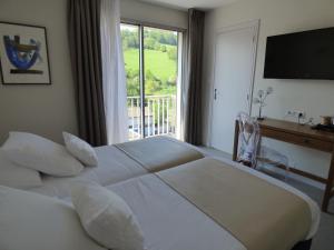 圣弗卢尔Cit'Hotel Grand Hotel L'Etape的卧室设有一张白色大床和一扇窗户。