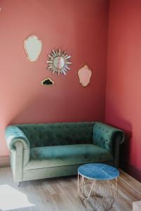 加普La Maison Augustine的红色墙壁的房间里一张绿色的沙发