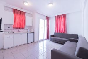 马尔马里斯Sezin Apart的带沙发的客厅和带红色窗帘的厨房