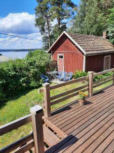 SäkyläPunavilla majoitus TASANKO的木甲板,配有野餐桌和建筑