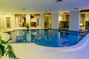 科威特Spice Hotel的一座大型游泳池,位于一座带大型游泳池的建筑中