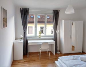 格拉茨Helle und gemütliche Wohnung in zentraler Lage的一间卧室配有书桌和一个带椅子的窗户。