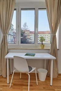 格拉茨Gemütliche Wohnung in zentraler Lage的白色的桌子和窗前的椅子