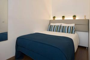 里斯本Cozy Studio Alvalade的一间卧室配有一张带蓝色床单和枕头的床。