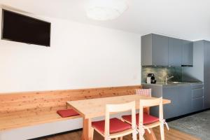 CluginHapimag Ferienwohnungen Andeer的厨房配有木桌和椅子