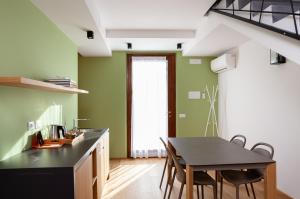 安科纳A3帕斯酒店的厨房设有绿色的墙壁和桌椅