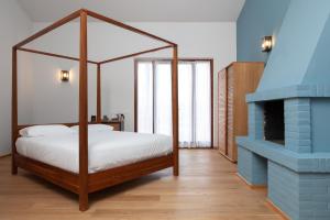 安科纳A3帕斯酒店的一间卧室设有一张天蓬床和一个壁炉