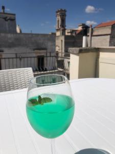 萨米凯莱-迪巴里Il rifugio di Vaaz的坐在桌子上的一杯绿色葡萄酒