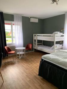 舍夫德Vandrarhemmet Östergatan的卧室配有两张双层床和一张桌子及椅子