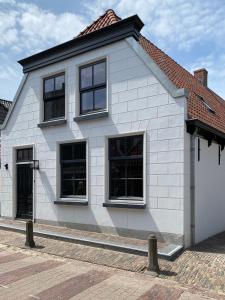 登堡Het Vergulde Visje的街上的白色房屋,设有黑窗