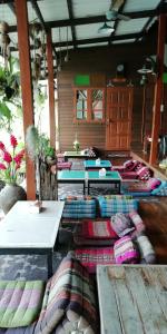 安帕瓦Baan Ing Suan的一间房间,地板上有很多桌子和枕头