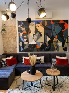 斯普利特豪华宫殿1号公寓的客厅配有蓝色沙发和绘画作品