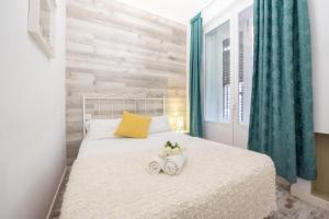 马德里Apartamentos Day Madrid PLAZA DE ESPAÑA Centro Gran Via Sol Malasaña的卧室配有白色床和2条毛巾