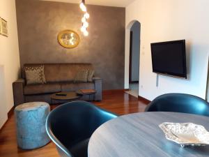 梅拉诺Appartements König的客厅配有桌椅和沙发