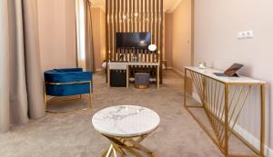 库塔伊西Newport Hotel Kutaisi的配有电视、桌子和沙发的客房