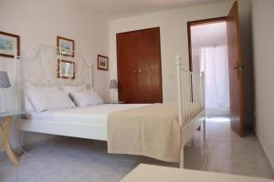 塞勒玛Salema Beach Private Villa的卧室配有白色的床和楼梯。
