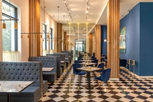 库塔伊西Newport Hotel Kutaisi的蓝色墙壁的餐厅里摆放着一排桌椅