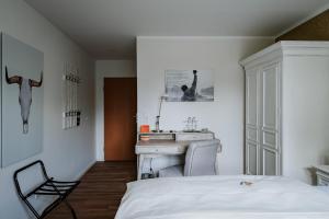 希登豪森RobrookS Hotel Garni的一间卧室配有一张床、一张桌子和一个水槽