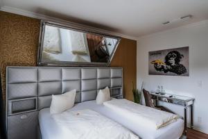 希登豪森RobrookS Hotel Garni的一间卧室配有一张床、一张书桌和一面镜子