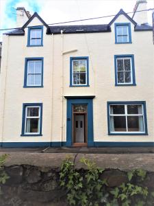 斯特兰拉尔Corsewall Arms Guest House的白色的房子,有蓝色的门