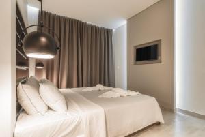 基普塞利Belussi Exclusive Suites的一间卧室配有带白色床单和枕头的床。