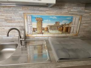 庞贝La casa di Vesta的厨房上方的墙上挂着一幅画,上面是水槽
